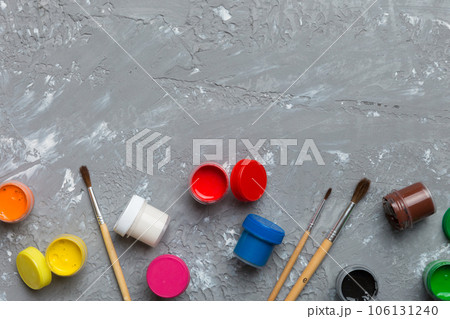 art palette with paint and brushes, close up. Top view with empty space. workplace for creativity. home teaching concept drawing 106131240
