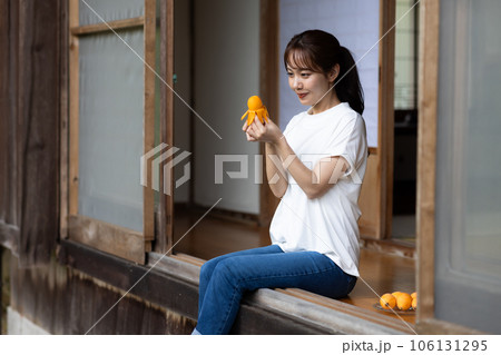 縁側で果物を食べる女性 106131295