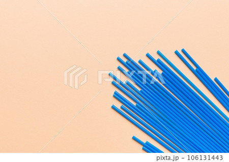 Heap of colorful plastic drinking straws on Colored background, flat lay. Copy Space for text 106131443