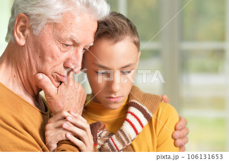 Thoughtful grandfather and his cute grandson at home Thoughtful grandfather and his cute grandson at home 106131653