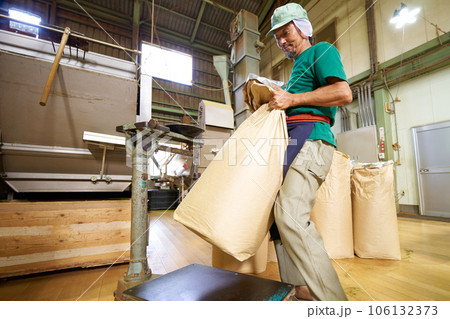 製茶工場で茶葉の重量を測る男性スタッフ 106132373