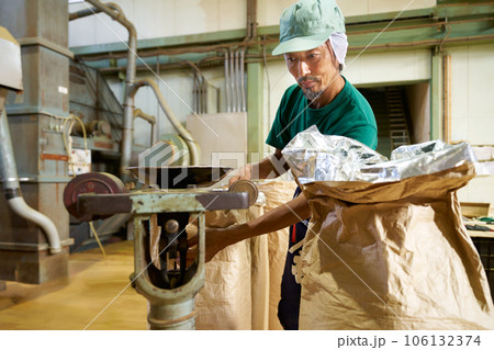 製茶工場で茶葉の重量を測る男性スタッフ 106132374