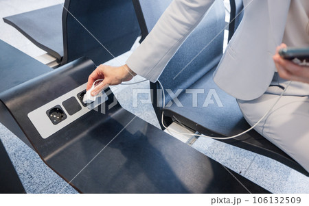 hands of businesswoman charging phone at airport hands of businesswoman charging phone at airport 106132509