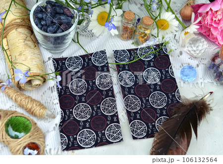 Still life with tarot cards, manuscript and magic wand on witch table in the garden. Occult, esoteric and witchcraft concept. Mystic wicca background with vintage objects 106132564