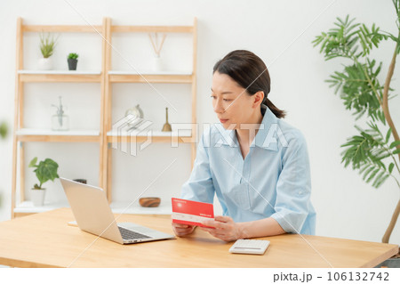 通帳を見て喜ぶ女性 106132742