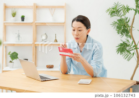 通帳を見て喜ぶ女性 106132743