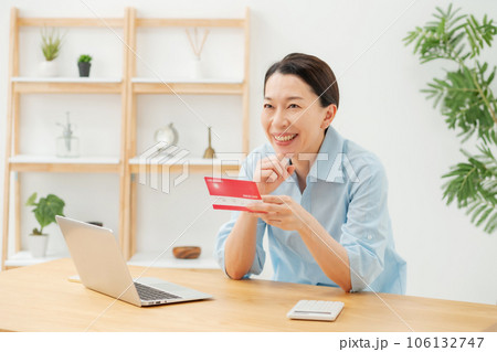 通帳を見て喜ぶ女性 106132747