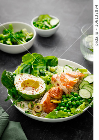 Salmon avocado bowl with broccoli, green peas, rice and fresh salad. Healthy food, top view Salmon avocado bowl with broccoli, green peas, rice and fresh salad. Healthy food, top view 106132894