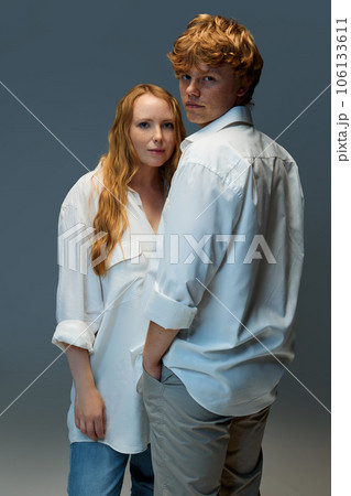 Portrait of young couple, in casual clothes, looking seriously and looking at camera on grey background. Fashion. 106133611