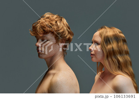 Beautiful red hair couple on grey background, fashion. Beautiful woman with bare shoulders looking at back of guy. 106133691