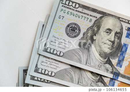 pile of one hundred US banknotes. Background with money american hundred dollar bills. 100 bills background. Lots of dollar bank notes on the table. The concept of financial business and crisis. 106134655