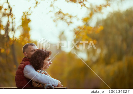 happy modern couple in park sitting on bench happy modern couple in park sitting on bench 106134827