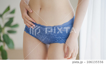 下腹部を触る下着姿の女性（ダイエット・お腹） 106135556