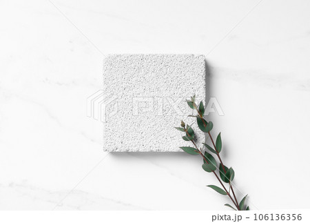 Empty white mockup scene for cosmetics product presentation made with porous stone and eucalyptus leaves. Empty white mockup scene for cosmetics product presentation made with porous stone and eucalyptus leaves. 106136356