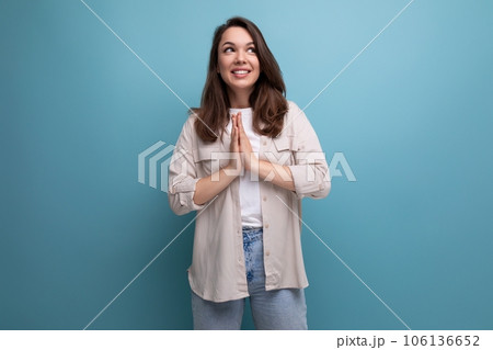 inspired smart brunette young woman in a stylish look owns information on a blue background with 106136652
