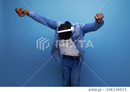 energetic american man with dreadlocks in denim jacket dancing to music with headphones 106136655