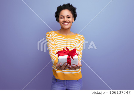 happy afro brunette 20s latin young woman holding out gift box happy afro brunette 20s latin young woman holding out gift box 106137347