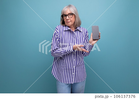 modern pensioner middle-aged woman with gray hair is studying smartphone gadget on bright studio modern pensioner middle-aged woman with gray hair is studying smartphone gadget on bright studio 106137376