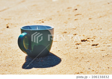 Green ceramic cups for coffee tea beverages on a sunny yellow sand Green ceramic cups for coffee tea beverages on a sunny yellow sand 106138832