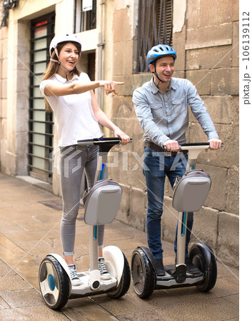 Young couple guy and girl walking on segway in streets of european city 106139112