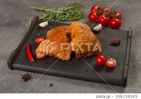 smoked boiled chicken thigh on a dark wooden board 106139165