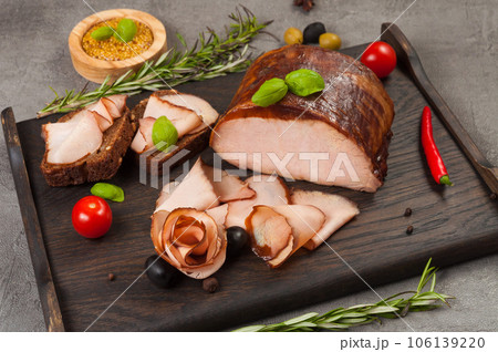 boiled and smoked pork delicacies on a dark wooden board 106139220