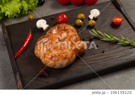 handmade boiled and smoked sausage on a dark wooden background handmade boiled and smoked sausage on a dark wooden background 106139228