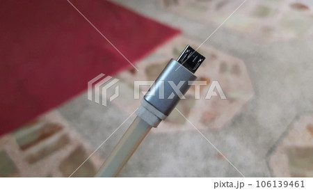 closeup view of a mobile phone charging usb micro cable isolated on blurred background closeup view of a mobile phone charging usb micro cable isolated on blurred background 106139461