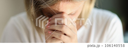 Exhausted and unhappy female with keeps her hands connected near forehead close-up. 106140558