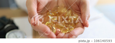 Nutritionist holding heap of vitamin capsules above his desk in medical clinic. Nutritionist holding heap of vitamin capsules above his desk in medical clinic. 106140593