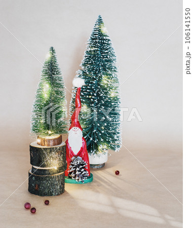 Selective focus, Merry Christmas and New Year holiday banner with a decorative Christmas trees and wooden Santa Claus on a craft background. Eco friendly New Year composition 106141550