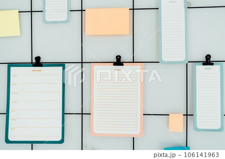 Close up grid mood inspiration board with mockup empty notes, Check lists and stickers on clamps for ideas, organizations, memories, wish lists with copy space. Plans for day, week. Selective focus 106141963