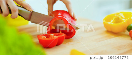 Closeup on housewife cutting red bell pepper on cutting board Closeup on housewife cutting red bell pepper on cutting board 106142772