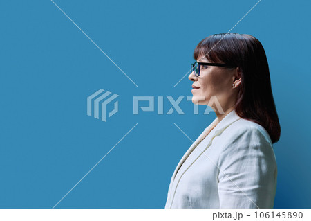 Serious mature business woman, profile view on blue studio background 106145890