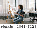 Woman painting a picture at the easel. 106146124