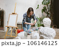 The artist with a palette and a brush in her hands. Close-up. 106146125