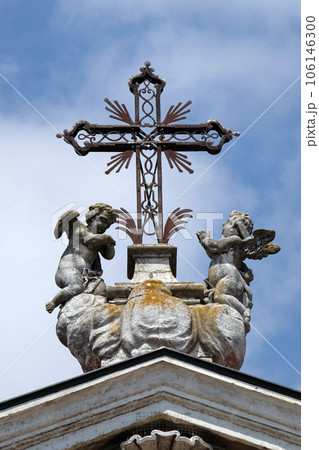 Angels kneeling under the cross, statue on facade of the Mantua Cathedral dedicated to Saint Peter, Mantua, Italy Angels kneeling under the cross, statue on facade of the Mantua Cathedral dedicated to Saint Peter, Mantua, Italy 106146300