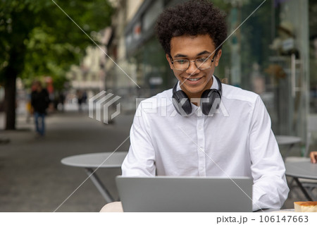 Curly-haired young businessman with headphones Curly-haired young businessman with headphones 106147663