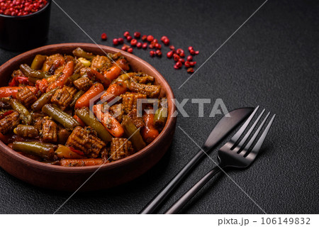Mix of vegetables corn, carrots, peppers, broccoli, onions in teriyaki sauce on a ceramic plate 106149832