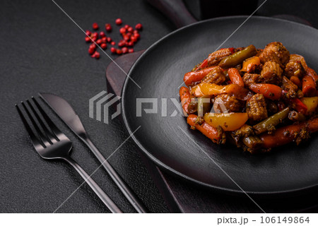 Mix of vegetables corn, carrots, peppers, broccoli, onions in teriyaki sauce on a ceramic plate 106149864