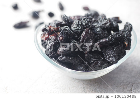 black raisin in a bowl on white background black raisin in a bowl on white background 106150488