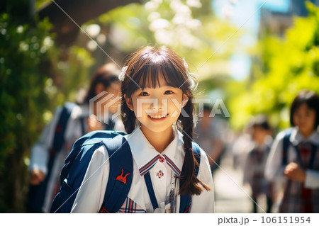 Happy japanese schoolgirl in uniform goes to school on a sunny day.  106151954