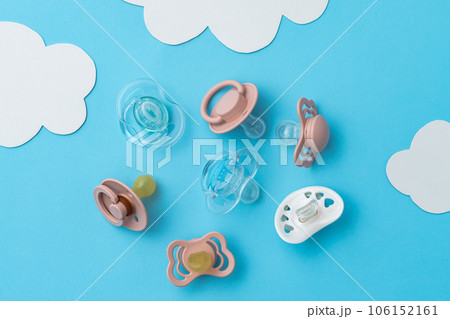 Pacifiers on blue background, newborn concept, top view of soothers, flat lay 106152161