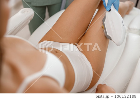 Closeup of female client getting epilation with ipl machine in beauty salon Closeup of female client getting epilation with ipl machine in beauty salon 106152189