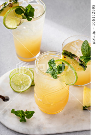 Mai tai cocktail in different glasses garnished with pineapple and lime 106152998
