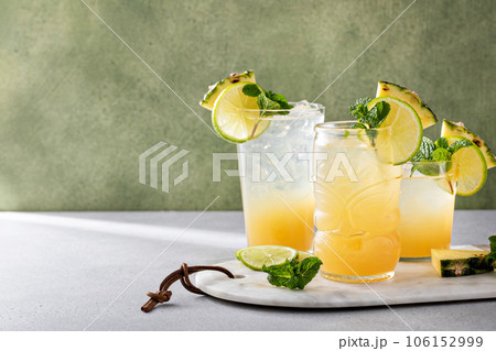 Mai tai cocktail in different glasses garnished with pineapple and lime Mai tai cocktail in different glasses garnished with pineapple and lime 106152999