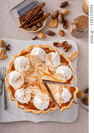 Pumpkin cheesecake swirl pie topped with whipped cream 106153095