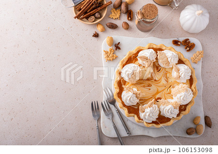 Pumpkin cheesecake swirl pie topped with whipped cream 106153098
