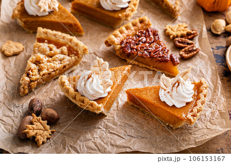Variety of Thanksgiving pie slices on parchment paper 106153167