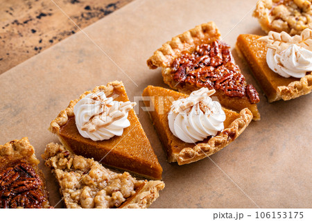 Traditional fall Thanksgiving pie slices, pumpkin and pecan pie Traditional fall Thanksgiving pie slices, pumpkin and pecan pie 106153175